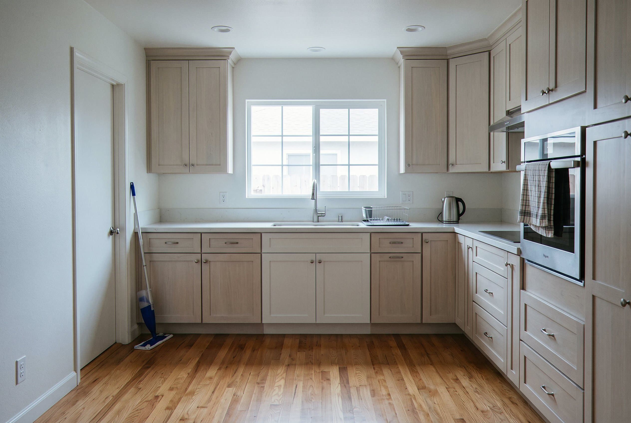 Kitchen restored after pipe repair and painting.